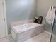 Close up of the bathtub showing the white tiled surround and white tile flooring at 1609 17Th W St, Bradenton, FL 34205