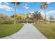 Picturesque park walkway leading to a serene pond, framed by lush greenery and palm trees, perfect for relaxation at 1721 8Th Street, Sarasota, FL 34236