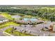 Aerial view of a community clubhouse, pool, and recreation area surrounded by lush landscaping and lakes at 17669 Cantarina Cv, Bradenton, FL 34211