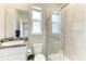 Bathroom featuring a tiled walk-in shower, granite vanity, and a bright window at 17669 Cantarina Cv, Bradenton, FL 34211
