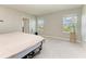 Bright bedroom featuring neutral tones, two windows, and a view of the neighborhood at 17669 Cantarina Cv, Bradenton, FL 34211