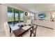 Sunlit dining area with a dark wood table, upholstered chairs, and sliding glass doors to the backyard at 17669 Cantarina Cv, Bradenton, FL 34211