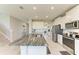 Bright kitchen features a large island with granite countertop and stainless steel appliances at 17669 Cantarina Cv, Bradenton, FL 34211