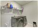 Modern laundry room with gray washer and dryer and storage shelving above at 17669 Cantarina Cv, Bradenton, FL 34211