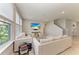 Bright living room with neutral decor, large windows, comfortable seating, and a wall-mounted TV at 17669 Cantarina Cv, Bradenton, FL 34211
