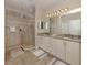 Bathroom with double sinks, granite countertops, and tiled walk-in shower at 23572 Awabuki Dr # 202, Venice, FL 34293