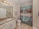 Inviting bathroom features a granite countertop, sink, and shower with decorative curtain at 23572 Awabuki Dr # 202, Venice, FL 34293