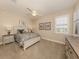 Cozy bedroom with a ceiling fan, a large window, and matching nightstands at 23572 Awabuki Dr # 202, Venice, FL 34293