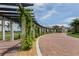 Community clubhouse entrance with manicured landscaping and brick driveway at 23572 Awabuki Dr # 202, Venice, FL 34293