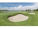 Picture of a well-maintained sand bunker on the golf course at Sarasota National with lake backdrop at 23572 Awabuki Dr # 202, Venice, FL 34293
