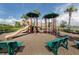 Community playground with a slide, multiple play areas, and benches for parents to sit and relax at 23572 Awabuki Dr # 202, Venice, FL 34293