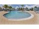Lush outdoor pool area offers a serene escape with sun loungers and umbrellas, perfect for relaxation at 23572 Awabuki Dr # 202, Venice, FL 34293