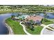 Aerial view of clubhouse with inviting pool surrounded by swaying palm trees on private peninsula at 23819 Collina Way # 102, Port Charlotte, FL 33980