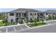 Beautiful condo exterior featuring stairs leading to the units, manicured landscaping, and convenient parking at 23819 Collina Way # 102, Port Charlotte, FL 33980
