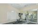 Community gym equipped with modern cardio machines and a mirrored wall for fitness at 23819 Collina Way # 102, Port Charlotte, FL 33980
