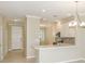 Bright kitchen with white cabinets, modern appliances, stylish backsplash, and a breakfast bar overlooking the entry at 23819 Collina Way # 102, Port Charlotte, FL 33980