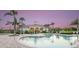 Community pool with clear blue water and a spacious lounging area with tables and chairs at 23819 Collina Way # 102, Port Charlotte, FL 33980