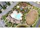 Overhead view of a community pool with a splash pad, playground, and green space next to parking at 259 Tierra Verde Way, Bradenton, FL 34212