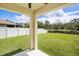 Scenic backyard with lush green lawn, white fence, and a tranquil pond at 259 Tierra Verde Way, Bradenton, FL 34212