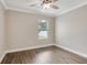 A bright bedroom featuring wood-look floors, a ceiling fan, and a window at 259 Tierra Verde Way, Bradenton, FL 34212