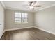 Bright bedroom showcases a window with blinds, wood-look flooring, and a ceiling fan at 259 Tierra Verde Way, Bradenton, FL 34212