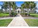 Community clubhouse featuring arched entry, lush landscaping, and a brick walkway on a sunny day at 259 Tierra Verde Way, Bradenton, FL 34212