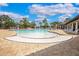 Community pool with lounge chairs, tables, pergola, and mature palm trees under a sunny, blue sky at 259 Tierra Verde Way, Bradenton, FL 34212