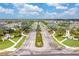 Wide street lined with palm trees leads into a residential community under a blue, cloudy sky at 259 Tierra Verde Way, Bradenton, FL 34212