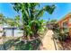 Landscaped backyard featuring an above-ground pool, tropical plants, and stone pathway at 3053 Monica Pkwy, Sarasota, FL 34234