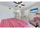 Bright bedroom features tile flooring, ceiling fan, TV, and built-in dresser at 3053 Monica Pkwy, Sarasota, FL 34234