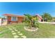 Inviting orange house has a manicured lawn with decorative stone accents surrounding a small palm tree at 3053 Monica Pkwy, Sarasota, FL 34234