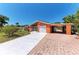 Charming orange home featuring an attached carport, screened in front porch, and spacious driveway at 3053 Monica Pkwy, Sarasota, FL 34234