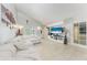 A bright and airy living room with a white sectional, entertainment center, and tiled floors at 3053 Monica Pkwy, Sarasota, FL 34234