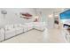 Bright living room featuring white tiled flooring, a large white sectional, and modern art at 3053 Monica Pkwy, Sarasota, FL 34234