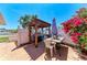 Outdoor patio with pergola, dining area, grill, and flowering shrubbery at 3053 Monica Pkwy, Sarasota, FL 34234