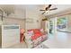 Bright sitting room with ceiling fan, white furniture, and sliding glass door to the backyard at 3053 Monica Pkwy, Sarasota, FL 34234