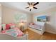 Cozy bedroom featuring two beds, a ceiling fan, and a wall-mounted television for entertainment at 306 Poinsettia Rd, Anna Maria, FL 34216
