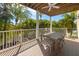 Spacious outdoor deck with ceiling fan, dining table and chairs surrounded by lush greenery and trees at 306 Poinsettia Rd, Anna Maria, FL 34216