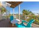 Outdoor deck with blue Adirondack chairs and a table overlooking lush greenery and the beach at 306 Poinsettia Rd, Anna Maria, FL 34216