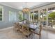 Elegant dining area featuring a wooden table, wood chairs, sliding doors, and an elegant chandelier at 306 Poinsettia Rd, Anna Maria, FL 34216