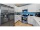 Updated kitchen with stainless steel appliances, white cabinets, and modern countertops at 306 Poinsettia Rd, Anna Maria, FL 34216