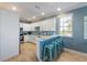 Bright kitchen features white cabinets, stainless steel appliances, blue backsplash, and breakfast bar with seating at 306 Poinsettia Rd, Anna Maria, FL 34216