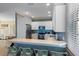 Beautiful kitchen with stainless steel appliances, white cabinetry, quartz countertop bar, and blue backsplash at 306 Poinsettia Rd, Anna Maria, FL 34216