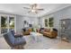 Bright living room with a comfortable leather sofa, a ceiling fan, and large windows that let in ample natural light at 306 Poinsettia Rd, Anna Maria, FL 34216