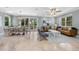 Spacious living room with travertine floors, a light blue color scheme, and sliding doors to the outside at 306 Poinsettia Rd, Anna Maria, FL 34216