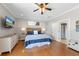 Bright main bedroom featuring wood floors, ceiling fan, tv, and ensuite bathroom at 306 Poinsettia Rd, Anna Maria, FL 34216