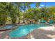 Outdoor pool with waterfall and jacuzzi surrounded by lush tropical foliage and lounge seating at 306 Poinsettia Rd, Anna Maria, FL 34216