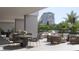 Luxury patio with comfortable seating areas, tables, and views of lush landscaping and palm trees at 325 Golden Gate Pt # 1004, Sarasota, FL 34236