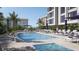 Condo pool area features lounge chairs, umbrellas, and pristine pool with inviting, clear blue water at 325 Golden Gate Pt # 1004, Sarasota, FL 34236