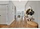 Hallway with wood floors, light walls, console table and large plants creating a bright, open space at 3533 Secluded Ct, Sarasota, FL 34240